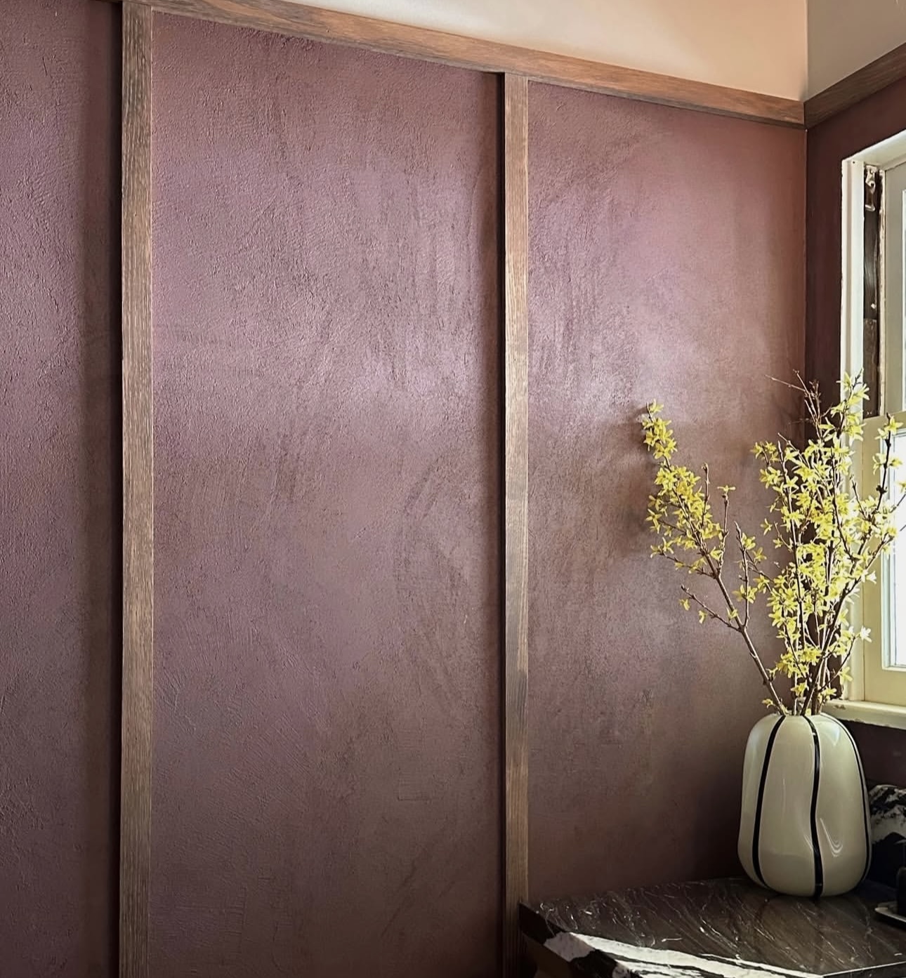 Interior wall with warm burgundy Concretta plaster finish