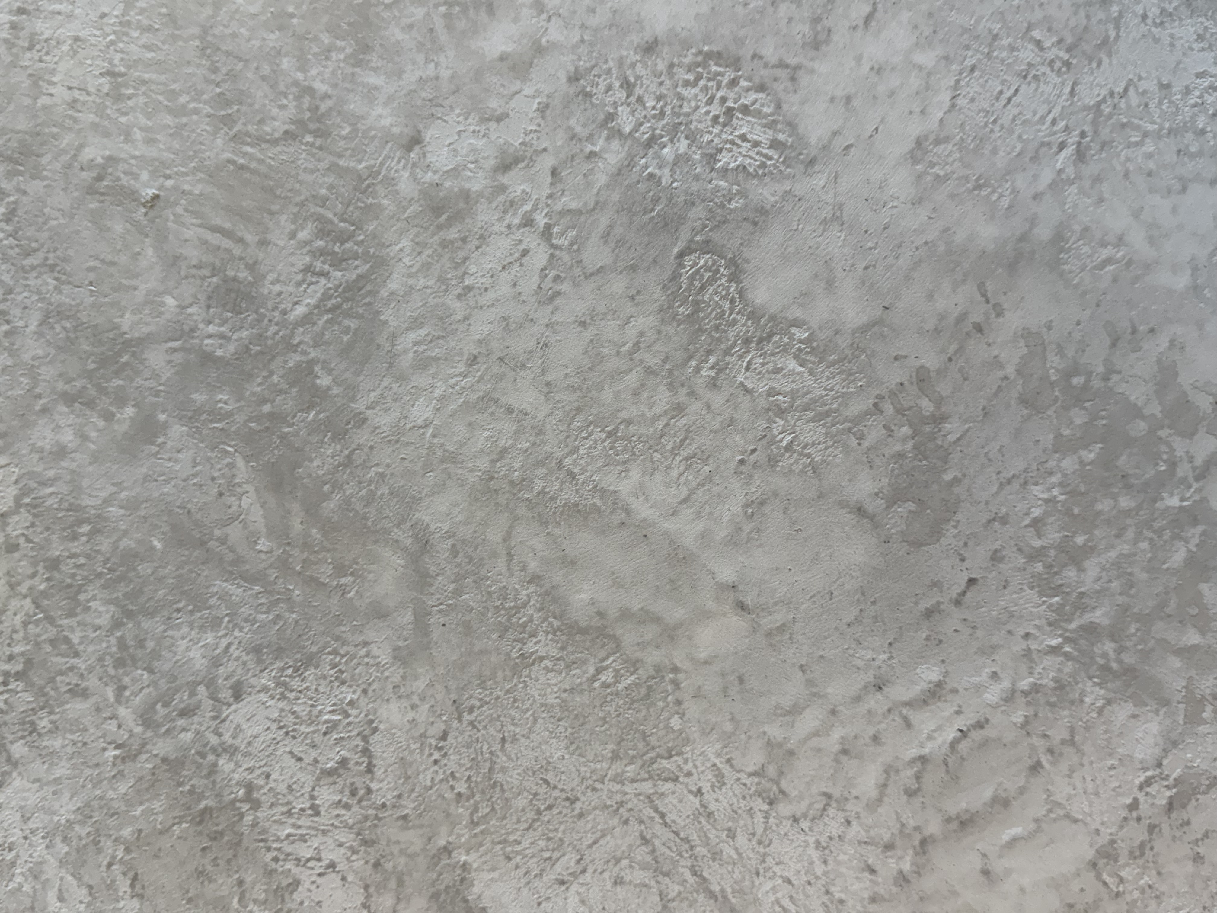 Close-up texture of natural lime plaster showing authentic handcrafted organic finish